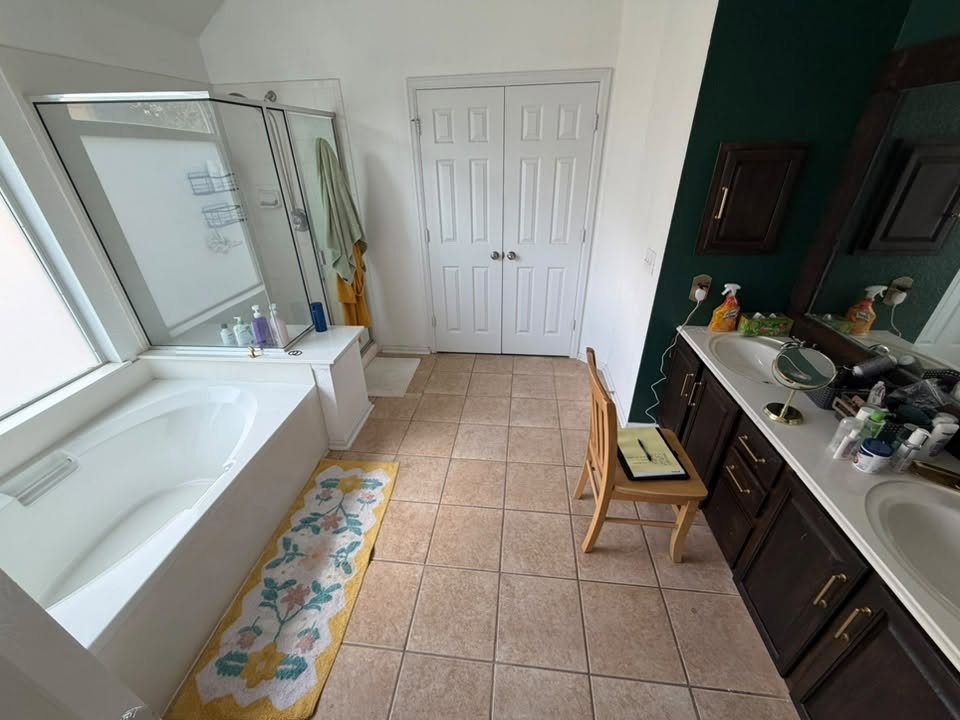 Before: the original bathroom with a built-in tub deck, tile floor and dark vanity